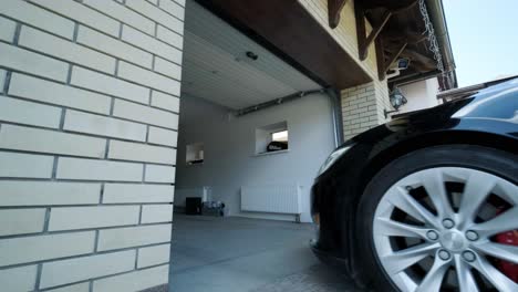 el conductor del coche usó el control remoto para abrir la puerta del garaje de la casa.