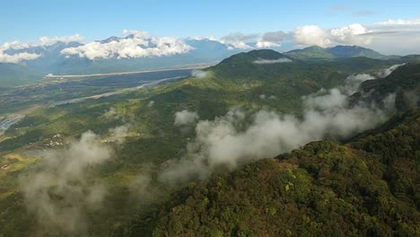 small clouds looming around mountains in valley