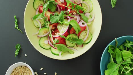 video de ensalada fresca con hojas verdes y cuencos con hojas de ensalada y nueces sobre fondo gris