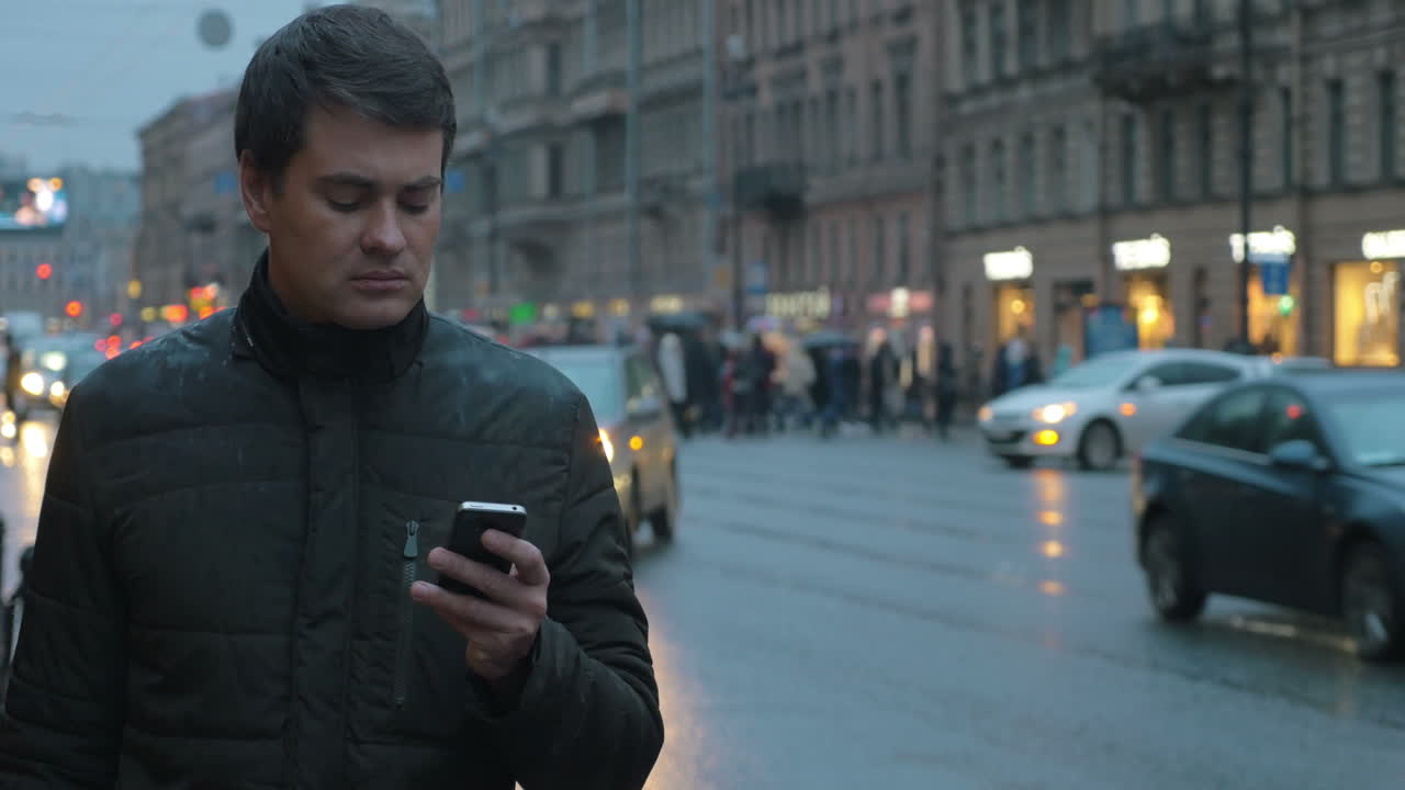mam enviando mensajes de texto en el móvil en la calle de la ciudad