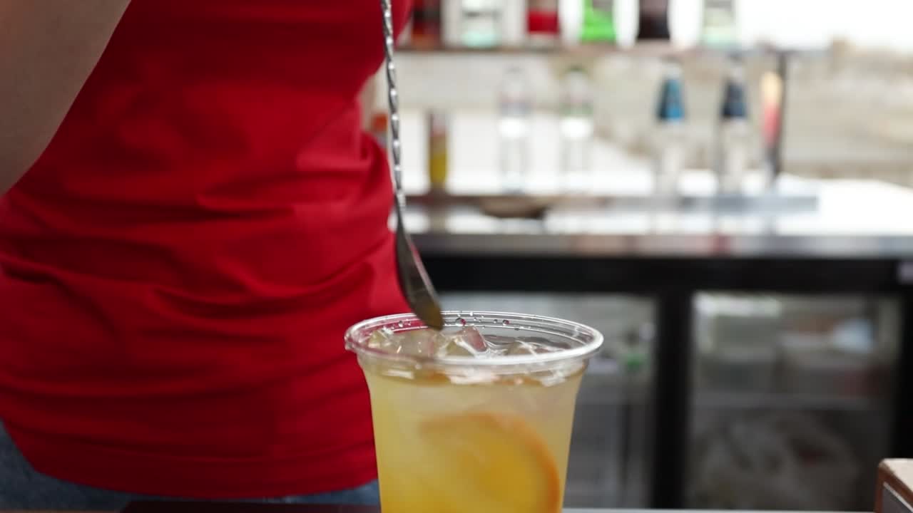 바텐더가 오렌지 조각과 얼음으로 테일을 만들고 있다