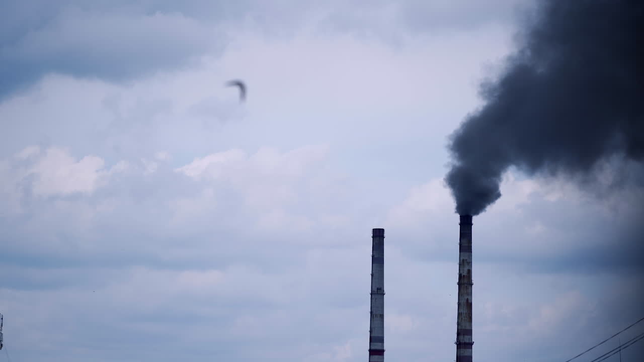 Smoke from industrial chimney. Factory with main chimneys expelling smoke into sky