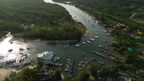 Toma-Aérea-De-Arriba-Hacia-Abajo-Del-Puerto-Turístico-En-Ao-Nang-Con-Crucero,-Estacionamiento-De-Lanchas-Motoras-En-El-Río-Al-Atardecer