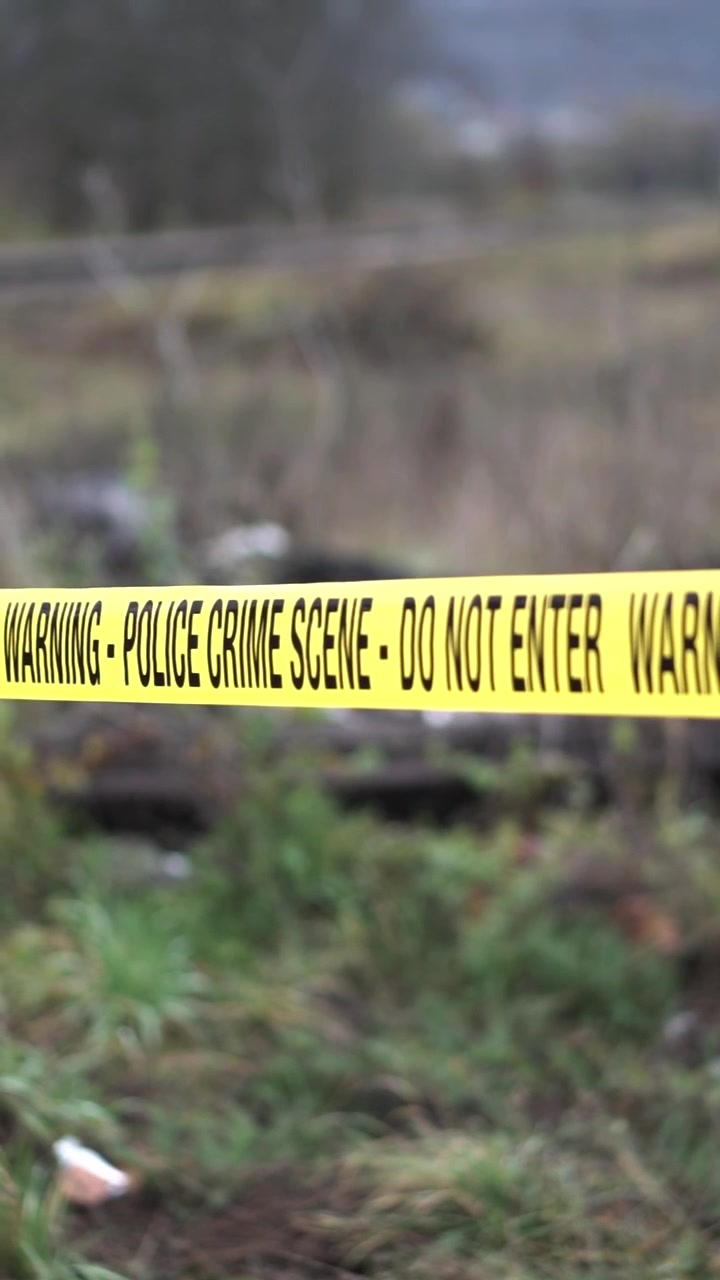 Vertical View of Police Crime Scene Do Not Enter Tape Ribbon in Park