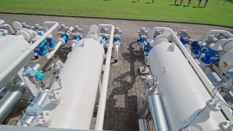 Tanques-De-Gas-Natural-En-Una-Estación-De-Bombeo-En-Letonia,-Toma-Panorámica-Aérea