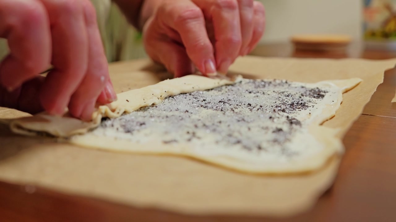 Nonna stende l'impasto di papavero zuccherato per panini fatti in casa, filmato al rallentatore