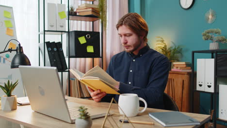 business man reading book turning pages smiling enjoying literature taking a rest relaxing at home