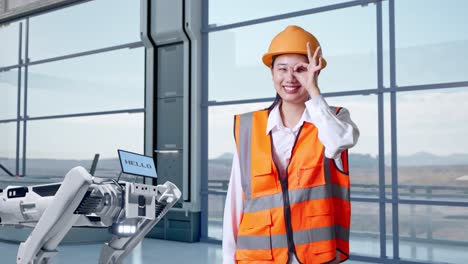 mujer ingeniera con robot en una fábrica moderna