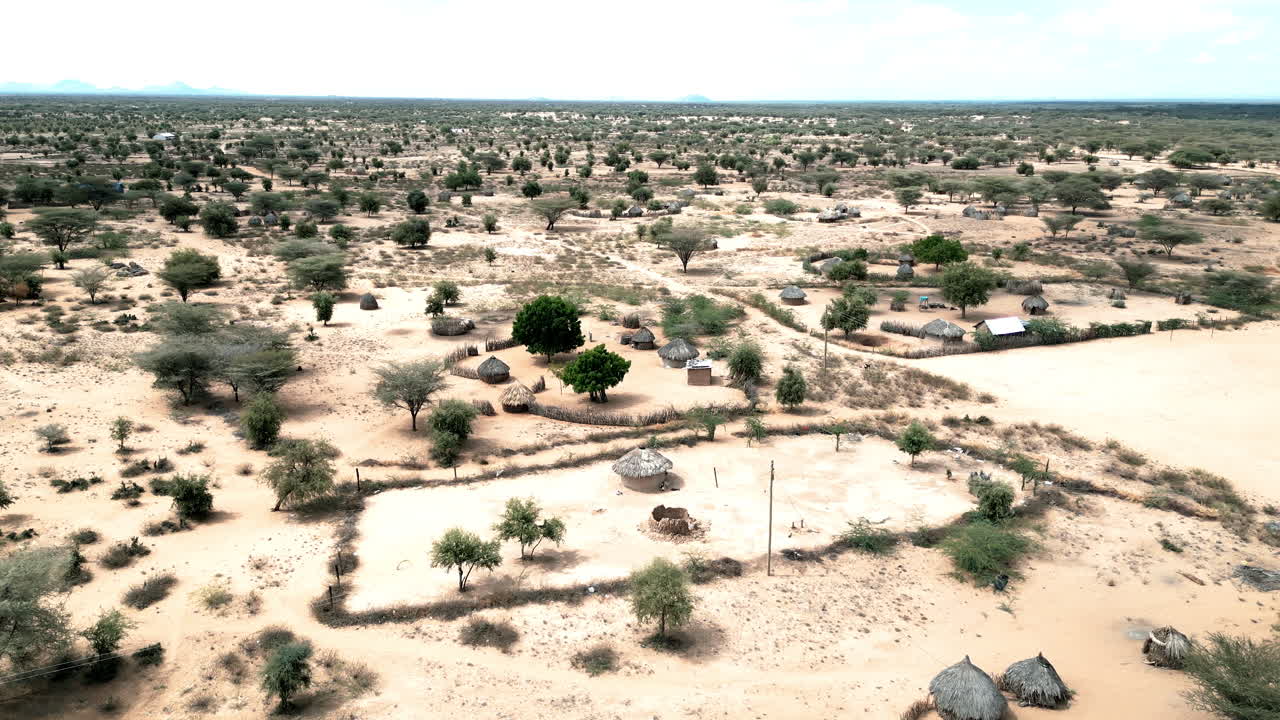 Aerial drone shot of a Northern Kenya village showing huts, landscape and home compounds