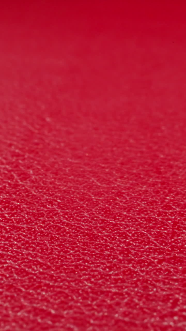 Texture of cow leather surface colored bright red as background extreme close view. Natural material for sewing different items. Abstract wallpaper