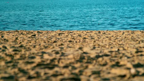 Der-Saubere-Sand-Am-Strand,-Umgeben-Von-Tiefblauem-Ozean-Unter-Einem-Hellen,-Sonnigen-Tag---Weitschuss