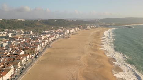 vista aérea de las olas en la costa de la playa de nazare durante el verano en portugal