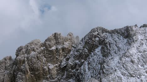 Toma-Aérea-De-Montañas-Nevadas-Que-Vuelan-A-Través-De-Las-Nubes-En-Dolomitas---Toma-Ascendente-Hacia-Atrás