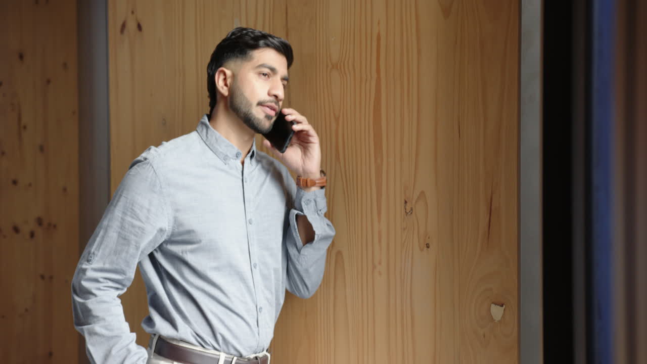 Talking on smartphone, businessman in office, wearing casual business attire