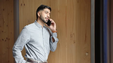 talking on smartphone, businessman in office, wearing casual business attire