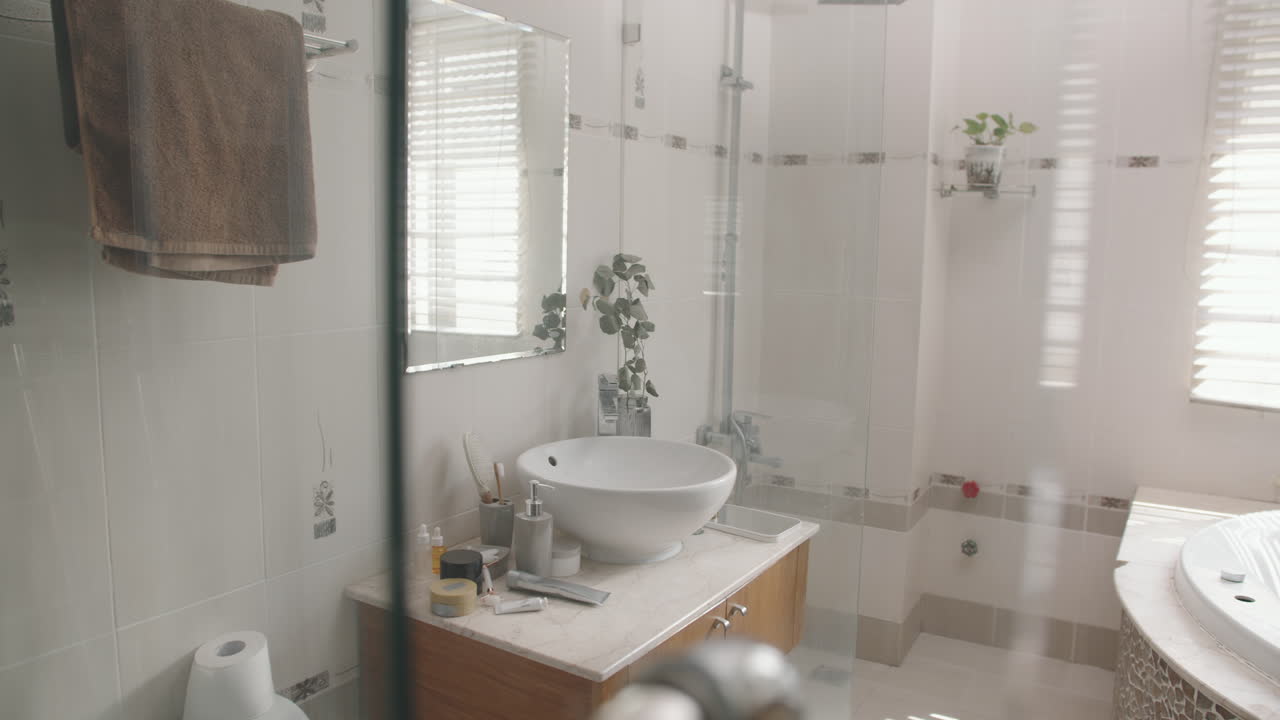 Young Woman in Bathrobe Looking at Herself in Bathroom Mirror