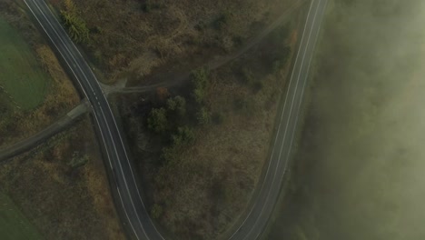 misty landscape with curved road in rural area, poland, aerial