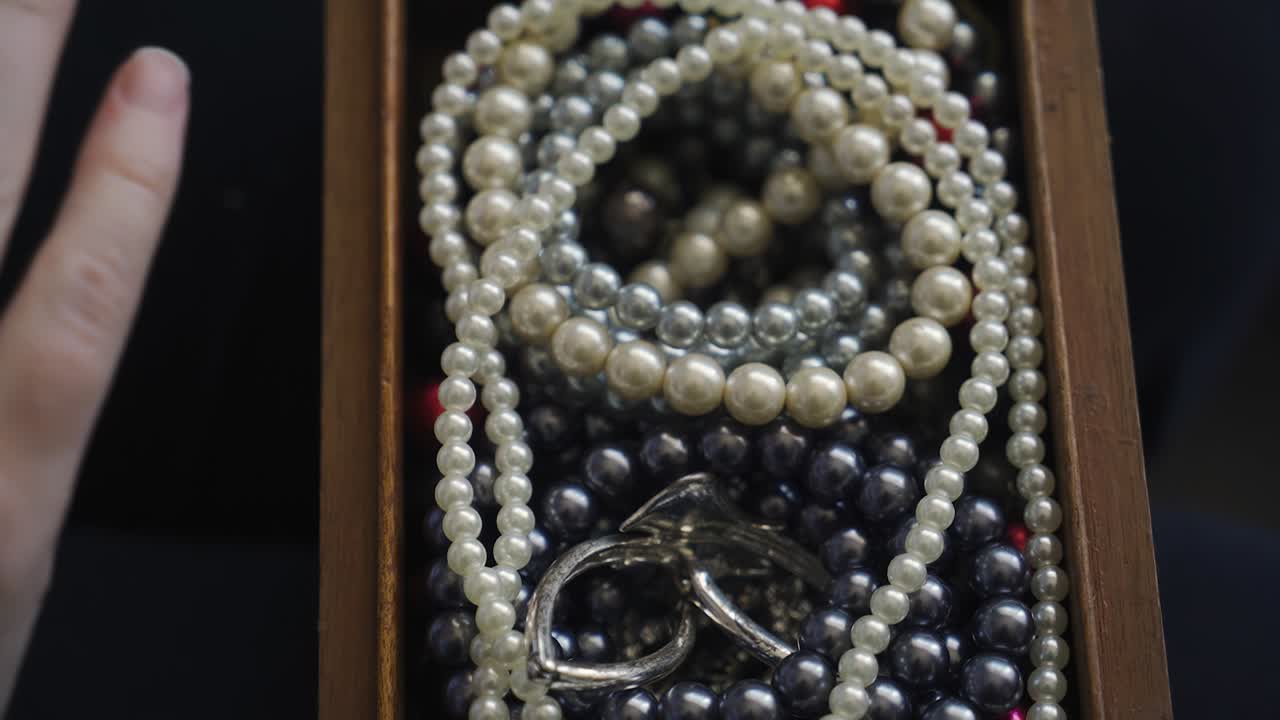 la mujer pone las joyas y joyas de disfraces en una caja de madera y la cierra. disparando de cerca desde arriba