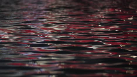 Ondulación-De-La-Superficie-Del-Agua-Con-Reflejo-De-Luz-Roja.