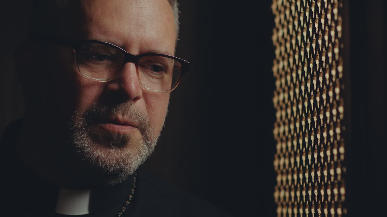 Mature Female Penitent and Contemplative Priest Talking during Confession