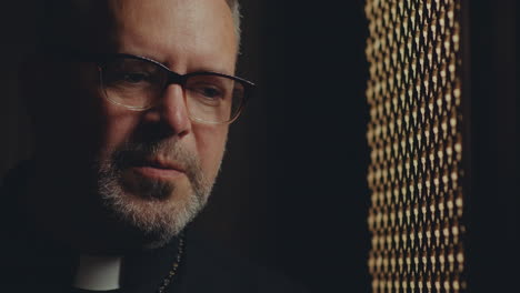 mature female penitent and contemplative priest talking during confession