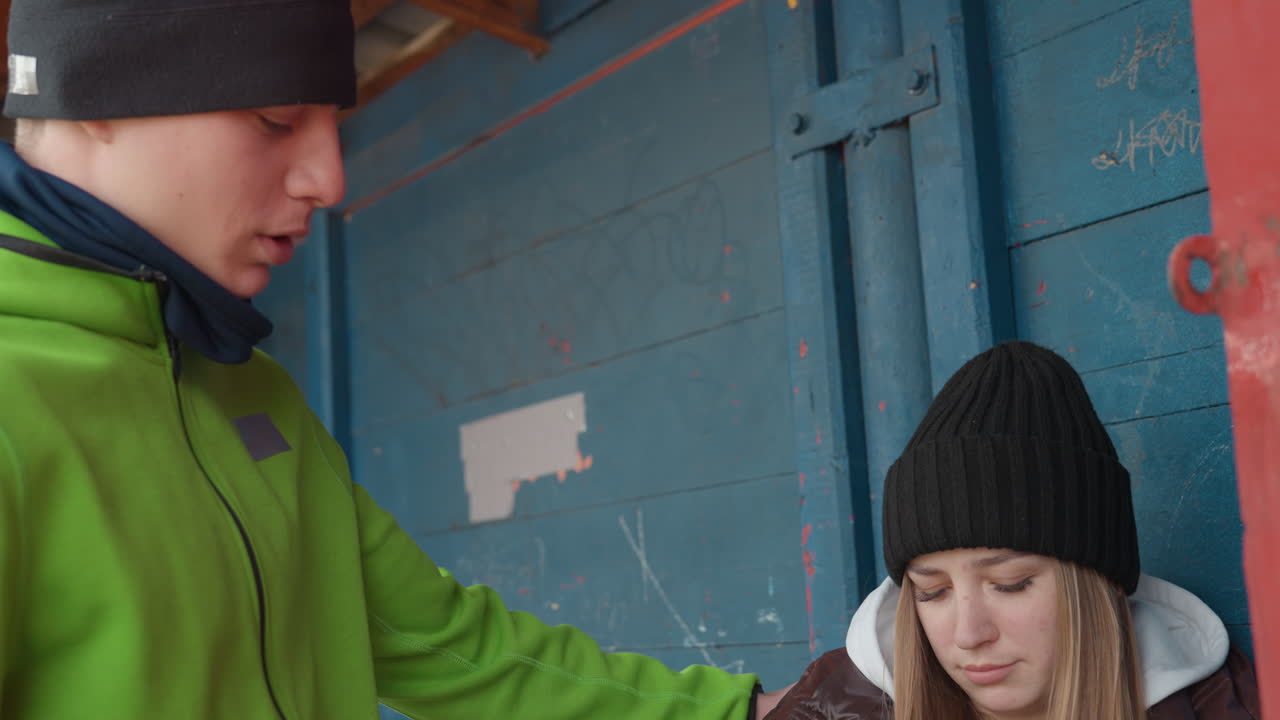 Мужчины помогают женщинам: проявление сочувствия между двумя людьми в городе; заботливый мужчина оказывает поддержку женщине у входа; чуткий мужчина предлагает помощь женщине в дверном проеме в городской среде