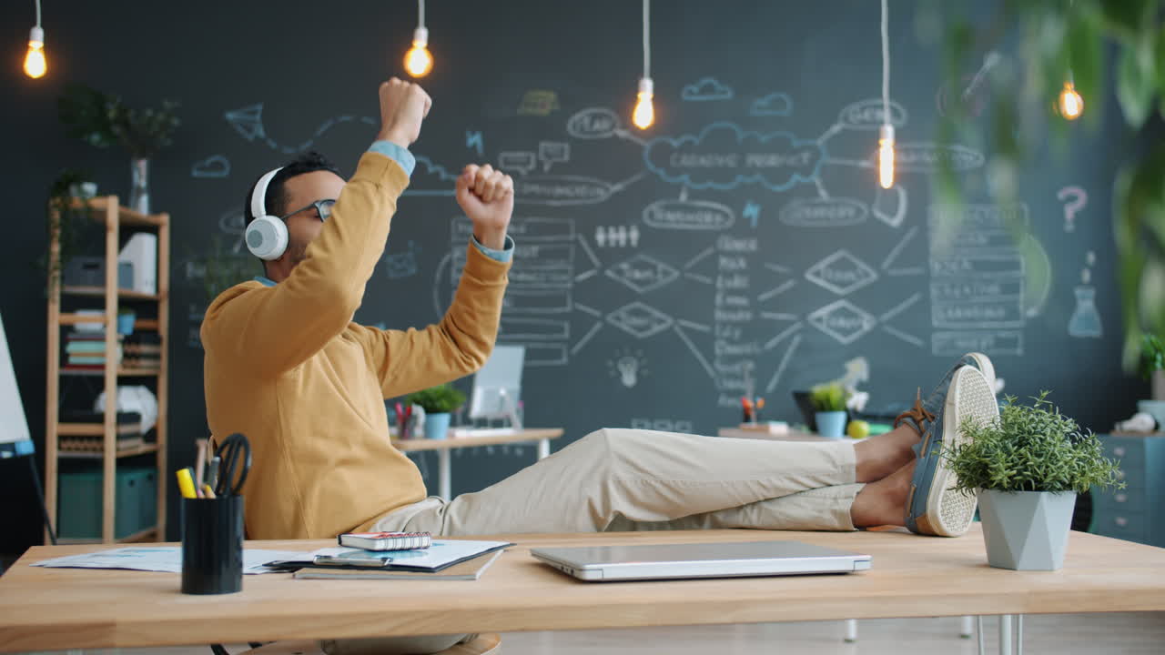 Happy Man Relaxing and Enjoying Music in a Modern Office