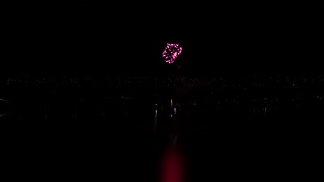 Aerial-drone-shot-of-Fireworks-display-over-a-large-lake-in-rural-Australia