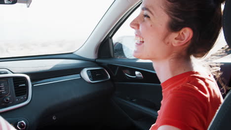 Young-white-couple-driving,-woman-in-front-passenger-seat