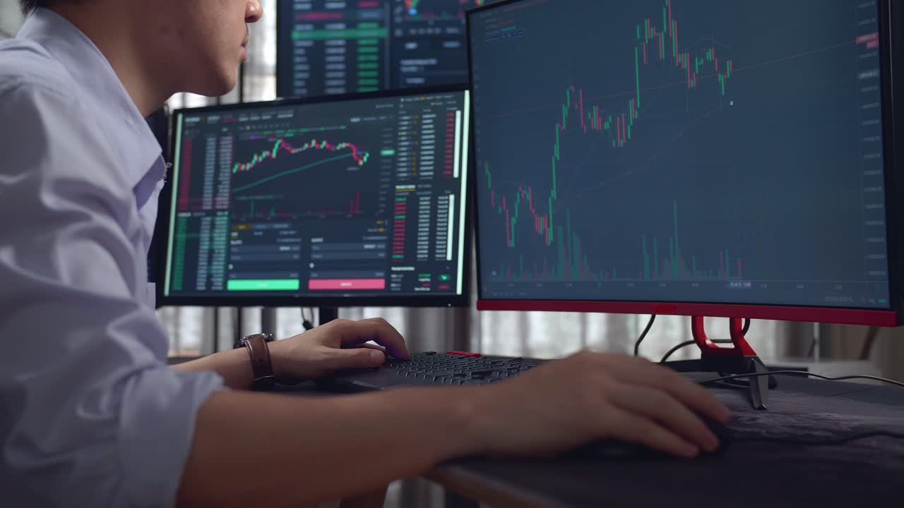 Male Stock Market Broker Looking Analyzing Graphs On Multiple Computer ...