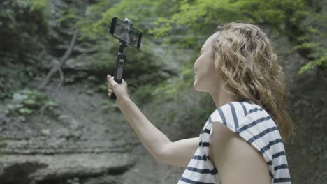 woman taking selfie in nature with a smartphone