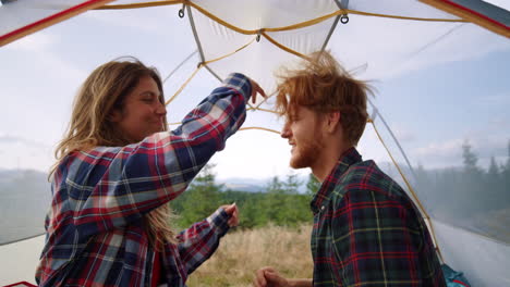 hombre y mujer sonrientes tocándose el cabello