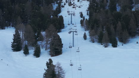 drone aerial of ski lift in chandolin, switzerland. chairlifts rise through snowy slopes and alpine forest creating a classic winter tourism and ski resort scene for travel and cinematic stock footage