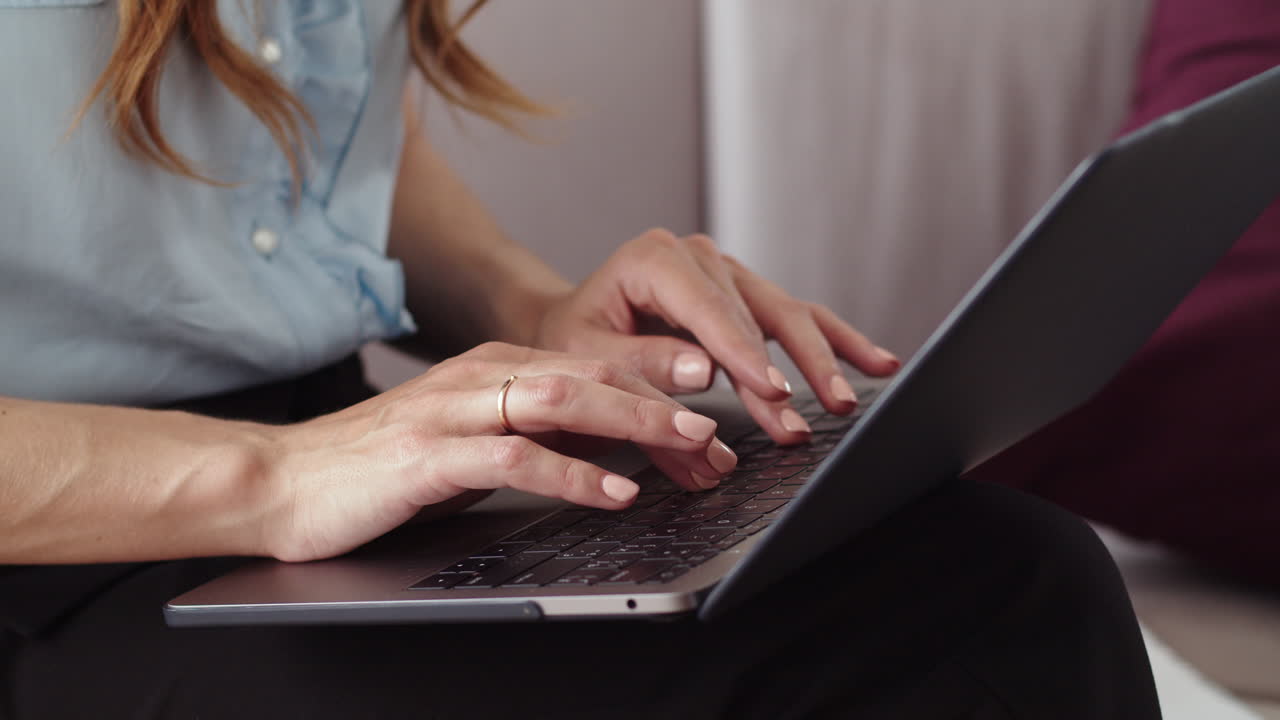 manos femeninas escribiendo en una computadora portátil en una oficina remota