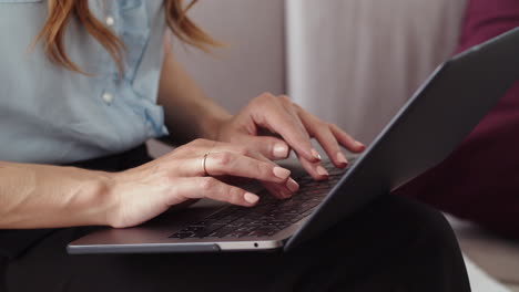 mains féminines en train de taper sur un ordinateur portable dans un bureau distant