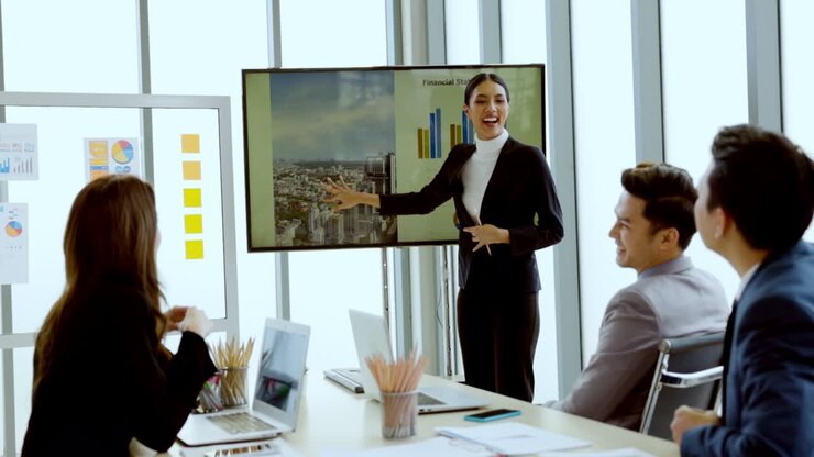 Grupo de empresarios asiáticos reunidos para planificar negocios en el mercado de valores y bienes raíces, presentando documentos comerciales e información de marketing en una moderna sala de reuniones. Estrategia de inversión en línea. Cuello blanco.