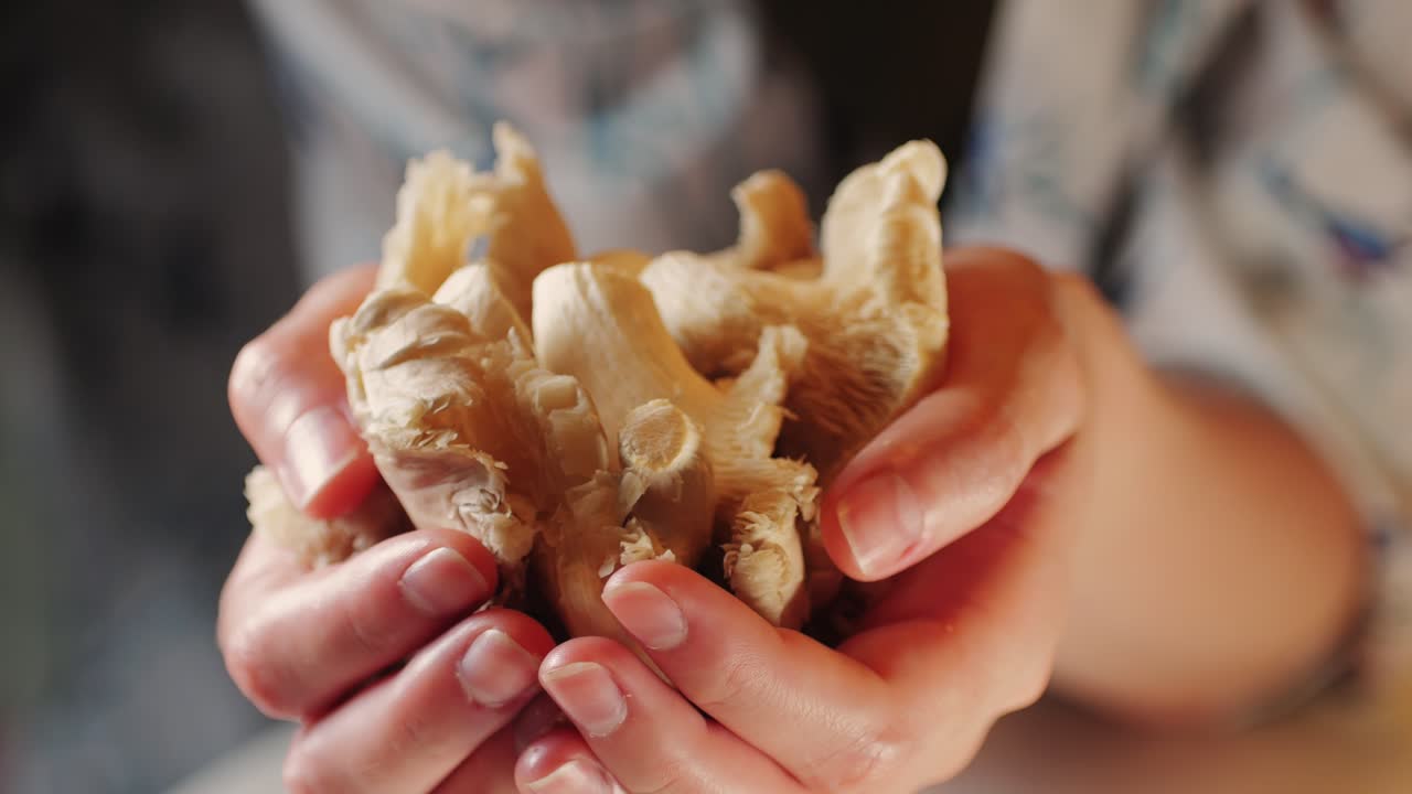 la mano de la mujer sostiene una canasta de setas de ostras pulmonares. un primer plano de la comida de los agricultores del supermercado.