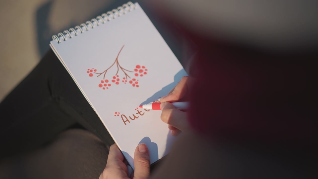 Person Drawing Autumn Berries and Writing in a Sketchbook