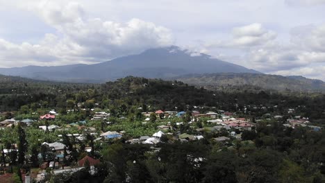 Increíble-Toma-Aérea-Volando-Hacia-El-Monte-Meru-Sobre-La-Ciudad-De-Arusha-Tanzania