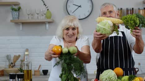 Ältere-Männer-Und-Frauen-Empfehlen-Den-Verzehr-Von-Rohem-Gemüse.-Reifes-Großelternpaar-In-Der-Küche