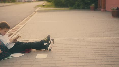 funny children with books in hands talk sitting on pavement