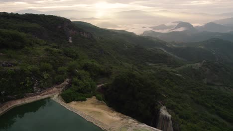 Drone-Hermosa-Vista-Del-Acantilado-Rocoso-De-Hierve-El-Agua-Con-Montañas-Forestales-En-México