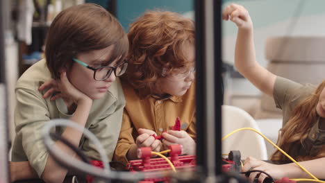 three children making tech project during science lesson