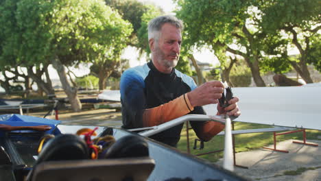 senior caucasian man preparing rowing boat for the water