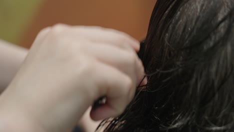 At the salon, a hairstylist combs a man&#039;s hair after a haircut
