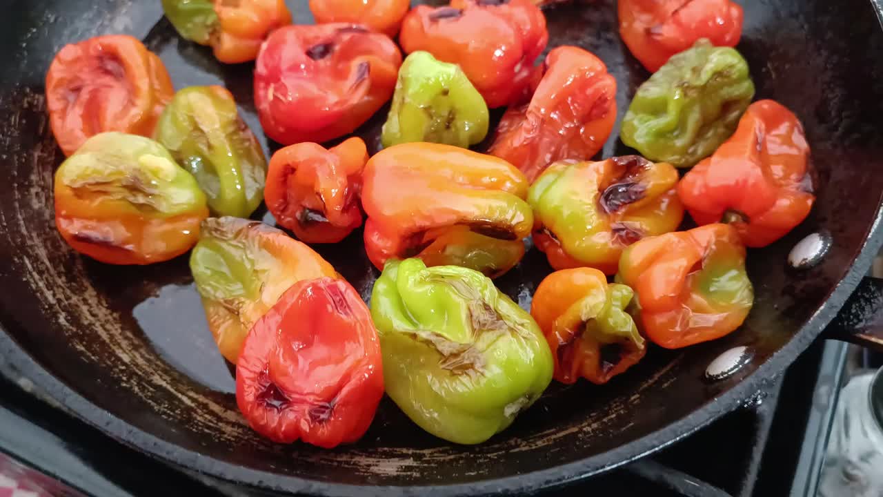 Delicious close-up of roasted habanero peppers on a hot pan, highlighting vibrant colors and textures during cooking.