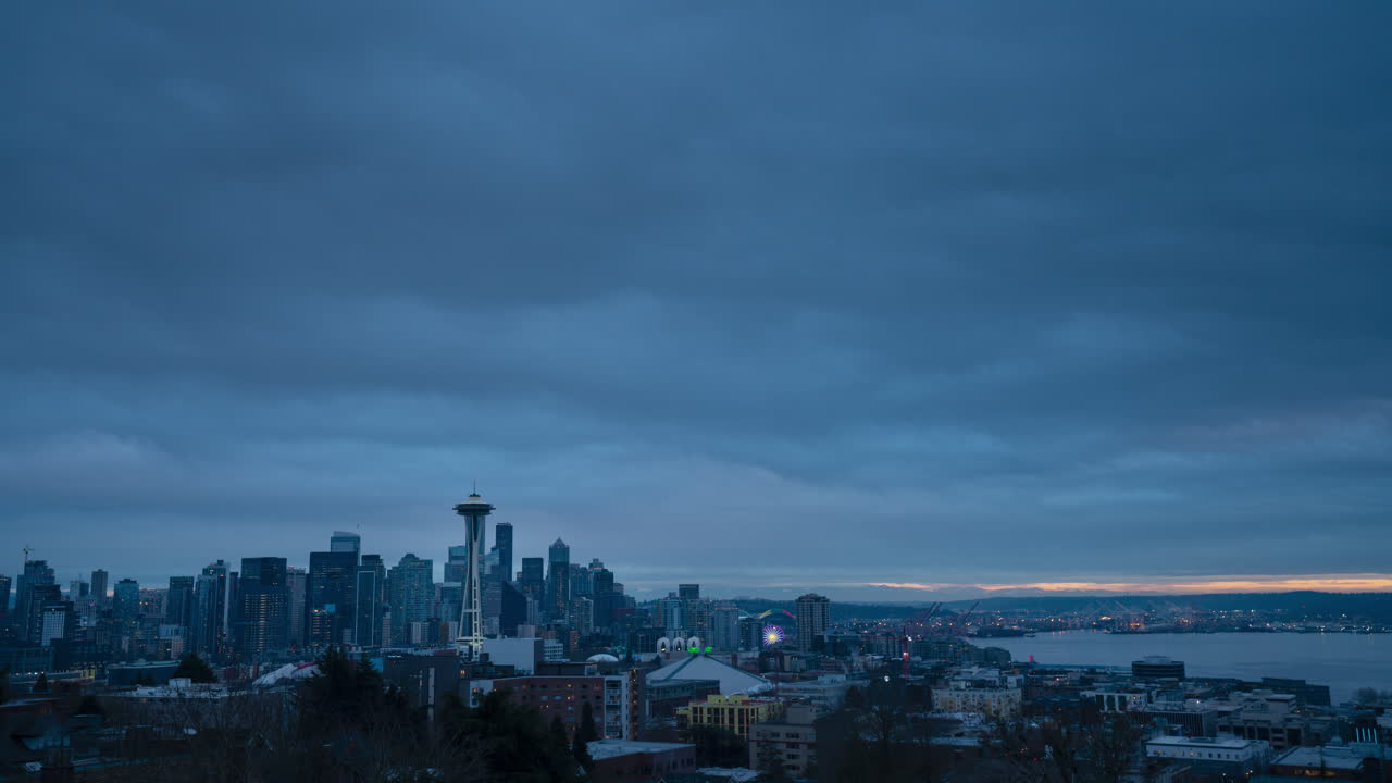 Fast moving clouds over Seattle skyline as the sun sets