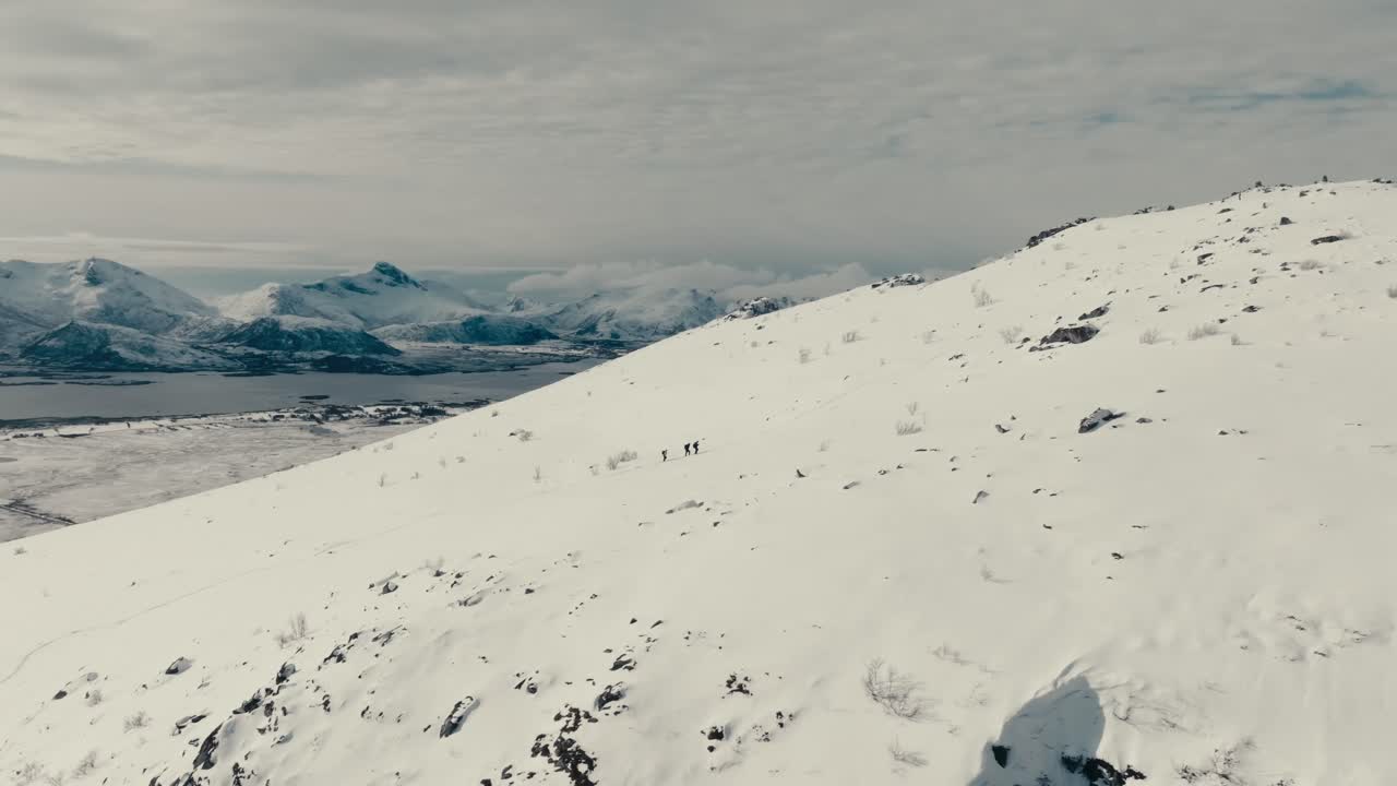 People Hiking On Steep Snow Mountain In Gimsoya Island, Vagan Municipality In Nordland County, Norway. Aerial Shot