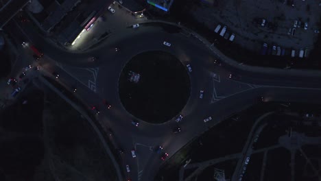 vista aérea de automóviles conduciendo en la autopista de rotonda en la ciudad nocturna. tráfico de automóviles en el paso elevado de la autopista del círculo. cruce de autopistas en la ciudad moderna desde el dron de arriba