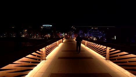 man walking in the street at night